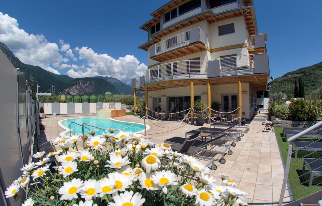 ein Hotel mit Pool und Blumen auf dem Balkon in der Unterkunft Ecohotel Primavera in Riva del Garda