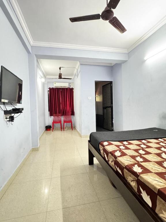 a bedroom with a bed and a flat screen tv at Saichha Guest House in Calangute
