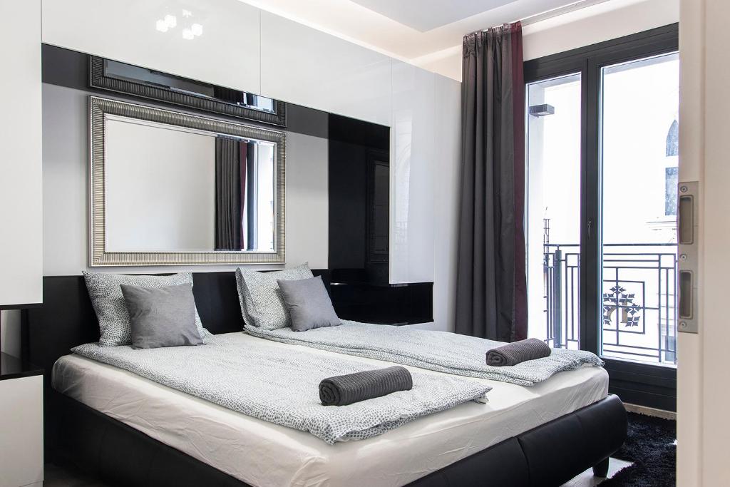 a bedroom with two beds and a large window at Luxe Central Apartments in Budapest