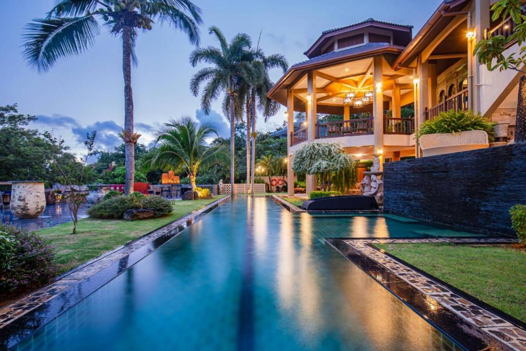 a house with a pool in front of a building at Bell Seaside Luxury Villa in Rawai Beach