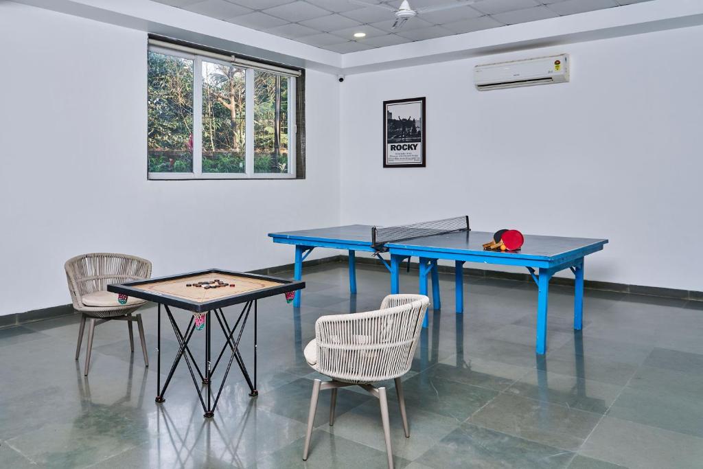 a ping pong table and chairs in a room at SaffronStays Indigo House in Karjat