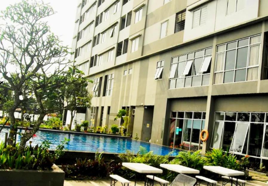 a building with a swimming pool in front of a building at Mountain View at The Edge in Cimindi-hilir