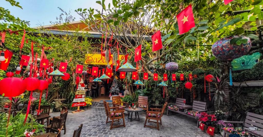 a garden with red lanterns and tables and chairs at Oáza coffee & bar in Hanoi