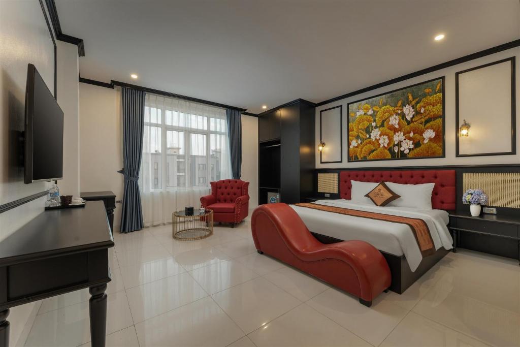 a bedroom with a large bed and a desk and a television at Royal Hotel & Spa in Ðồng Ky