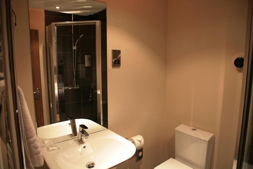 a bathroom with a sink and a toilet at The Buxted Inn in Buxted