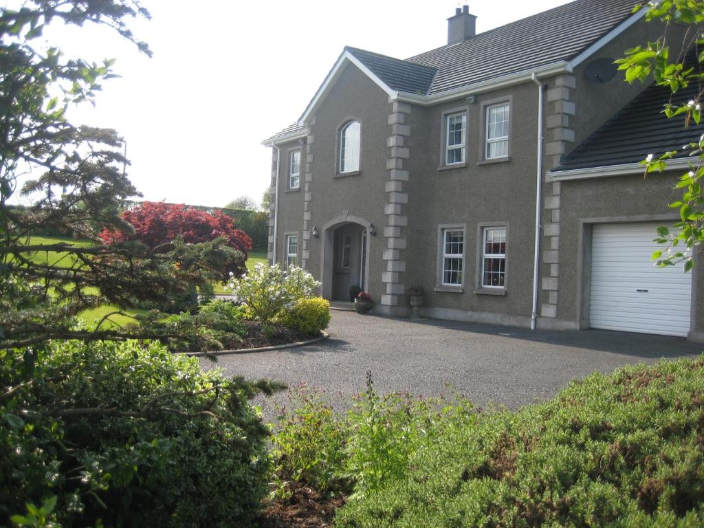 a house with a driveway in front of it at Drumspittal House B&B in Armagh
