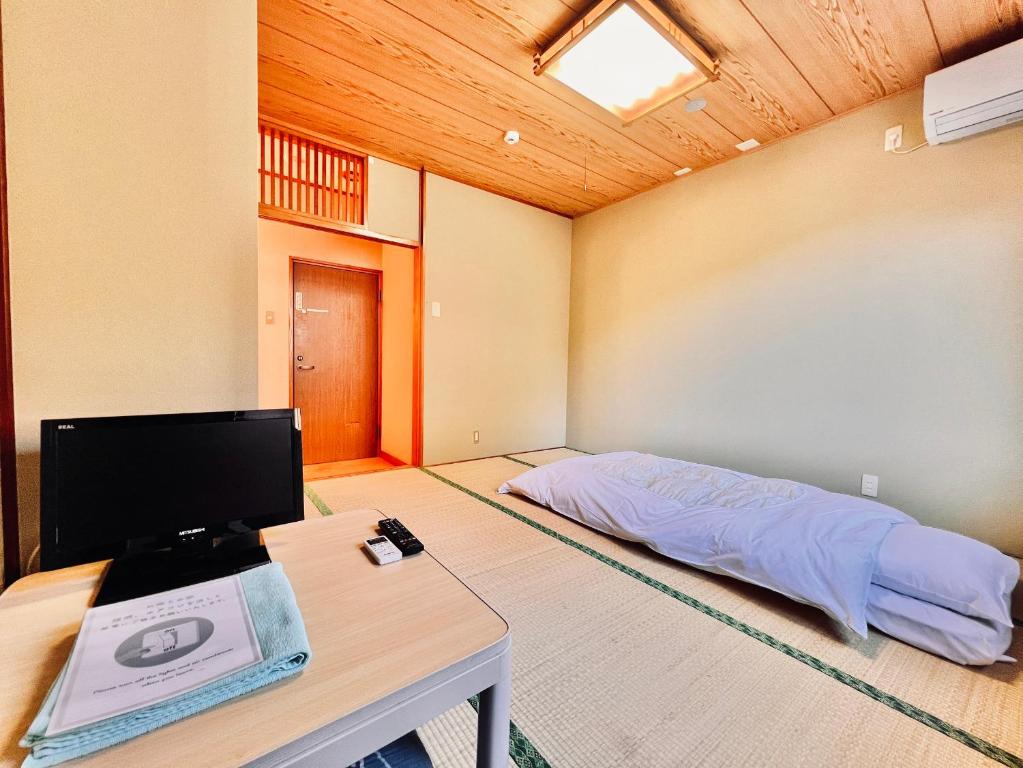 a room with a bed and a desk with a computer at 神庭-kaniwa- in Chichibu