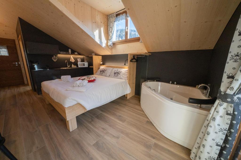 a bedroom with a bed and a bath tub at Appartamenti Casa Sabry in San Niccolò Comèlico