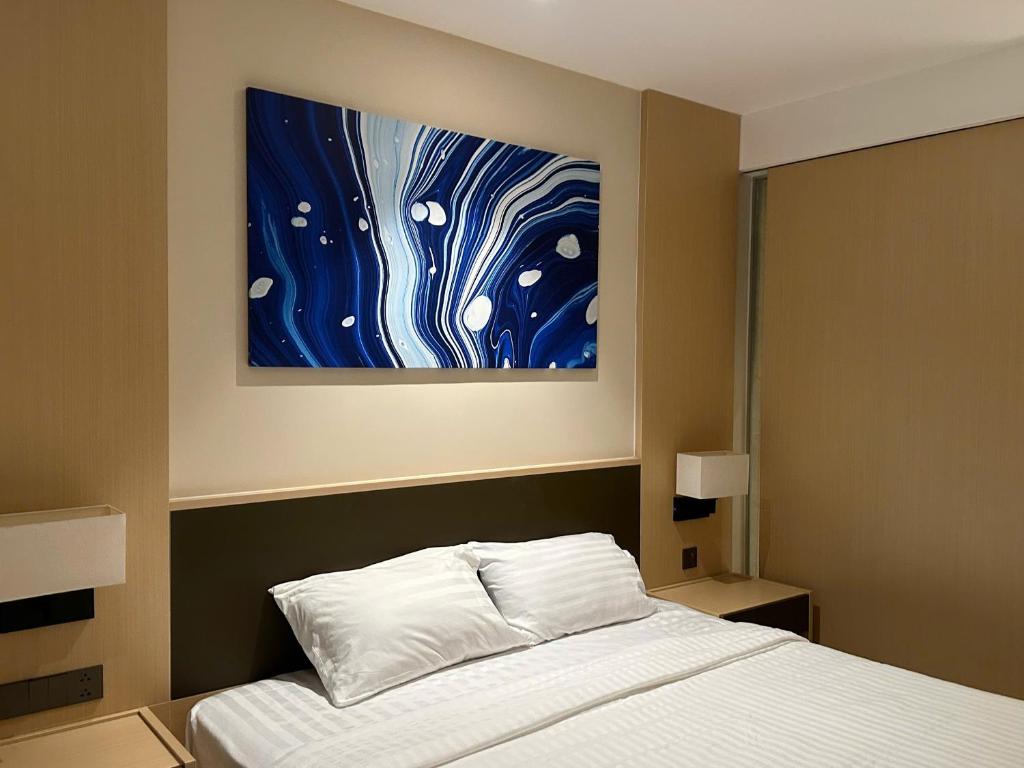 a bedroom with a bed and a painting on the wall at Arena Oceanview Cam Ranh - Infinity swimming pool in Cam Ranh International Airport
