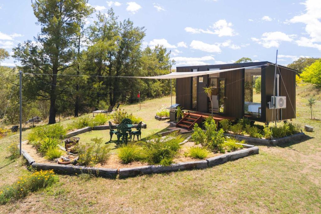 a tiny house in a field with a garden at Kanimbla Sunsets by Tiny Away in Kanimbla