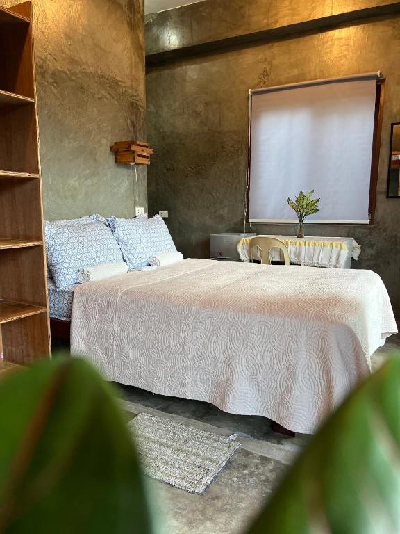 a bedroom with a bed with a large mirror on the wall at Balay Yuhom in General Luna