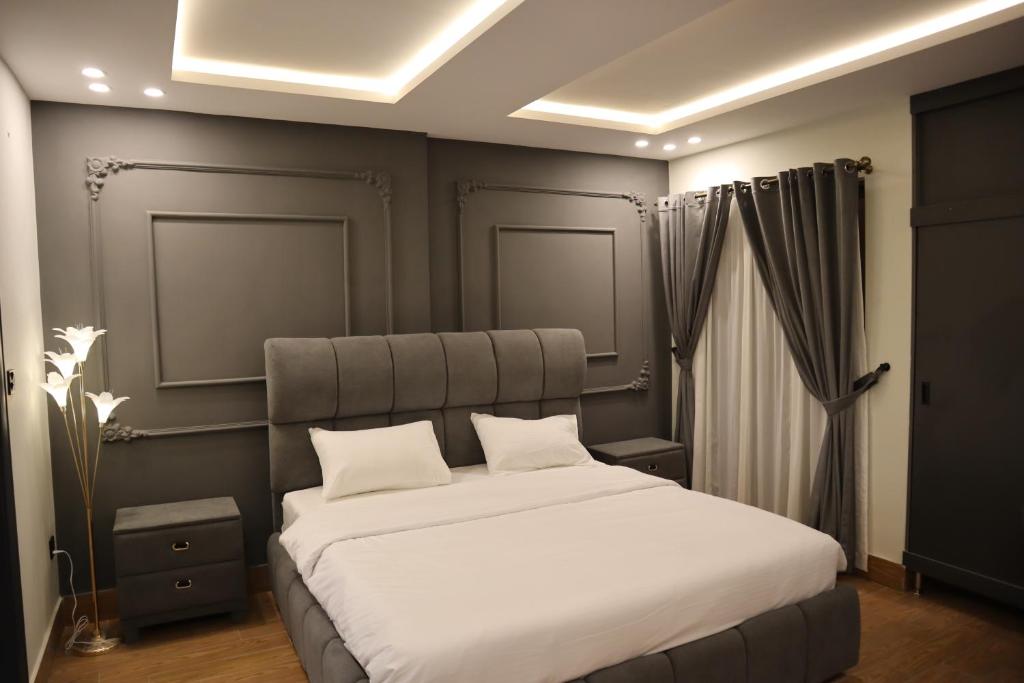 a bedroom with a large bed with white sheets at Bahria Premium Hotel in Rawalpindi