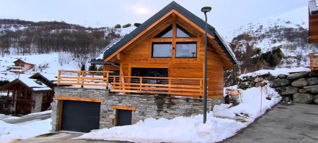 a log cabin in the snow with a large window at Le val'heureux in Valloire
