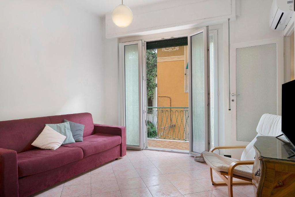 a living room with a purple couch and a balcony at Il Mughetto in Rapallo