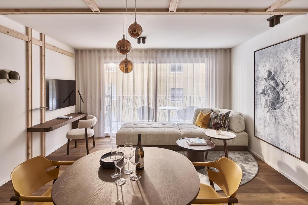 a living room with a couch and a table and chairs at Laudinella Apartments in St. Moritz