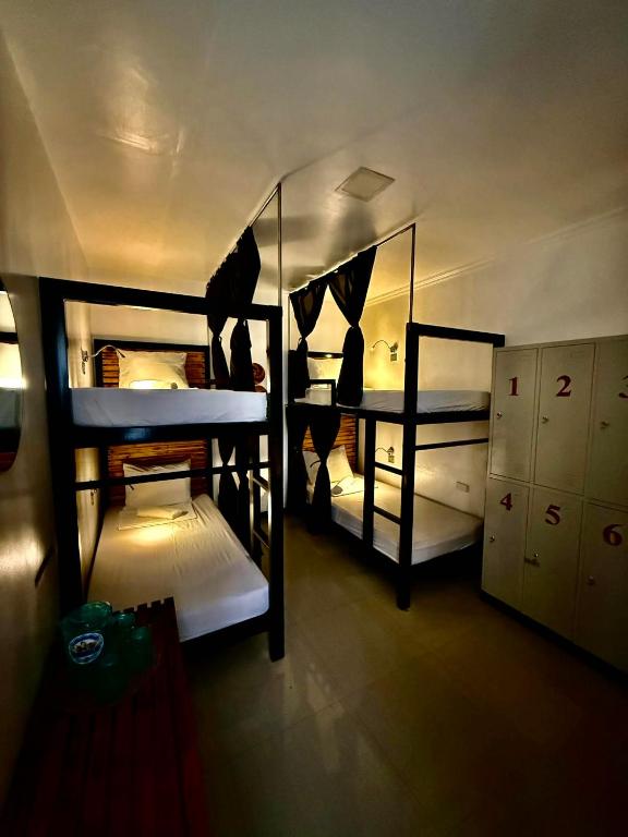 ein Zimmer mit drei Etagenbetten in einem Gebäude in der Unterkunft Bakawan Hostel in Coron