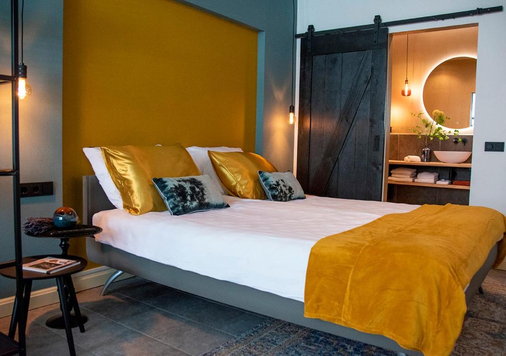 a bedroom with a large bed with yellow walls at B and B Suite No.3 in Gorinchem