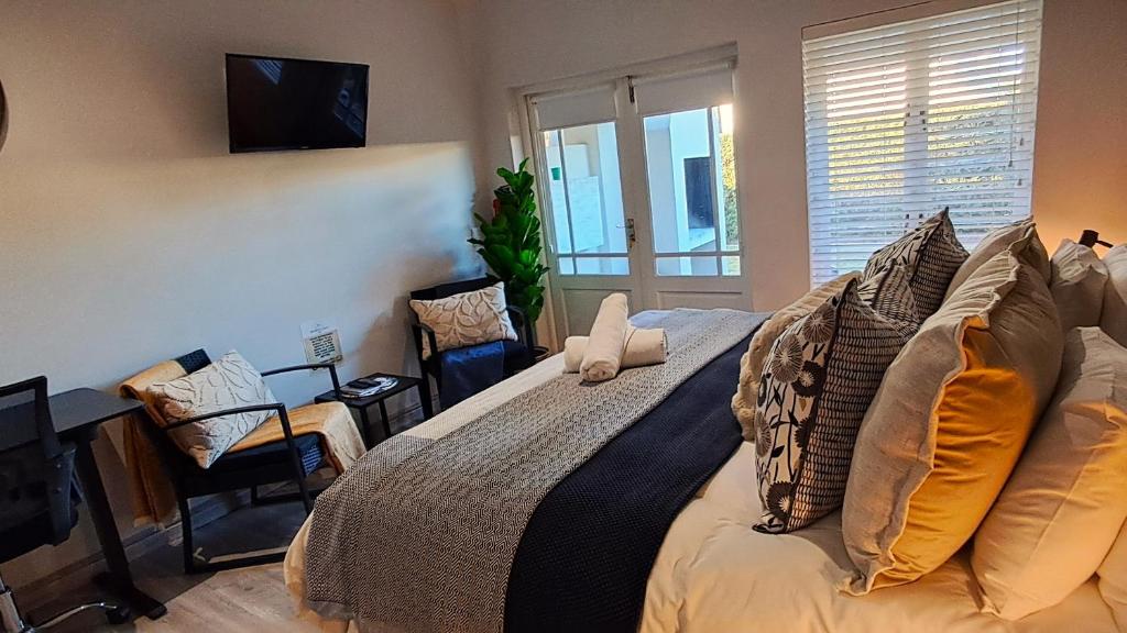 a bedroom with a bed with pillows and a television at Seaside at The Dunes in Plettenberg Bay