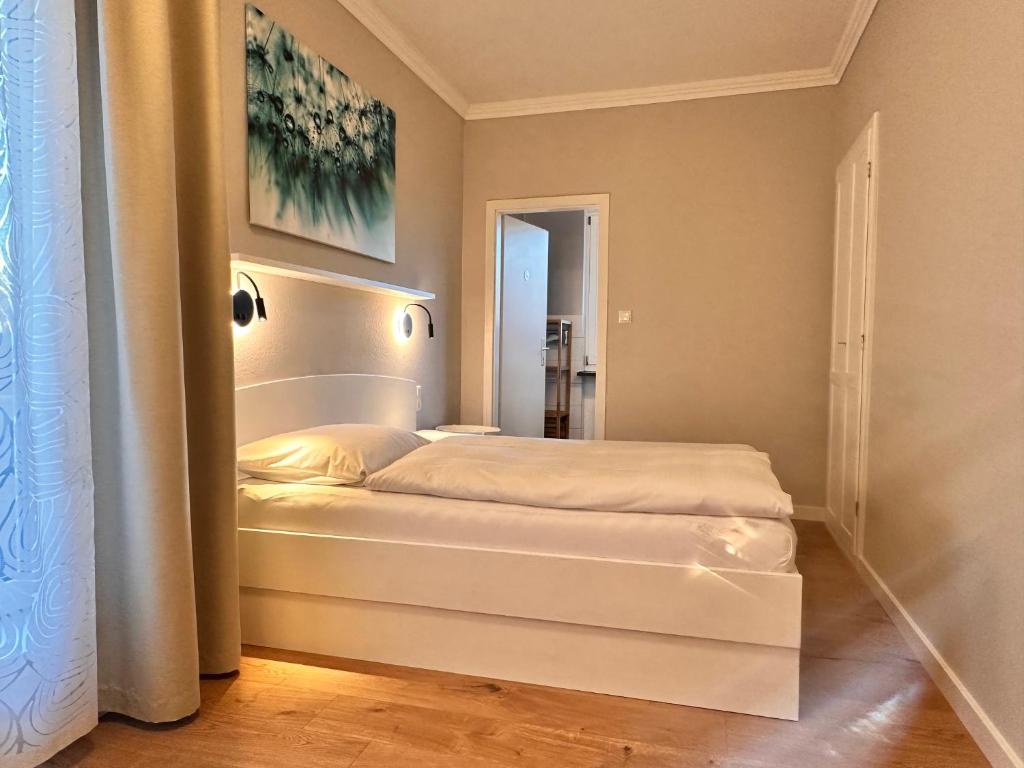 a bedroom with a white bed in a room at Hotel Villa Solln - free parking in Munich