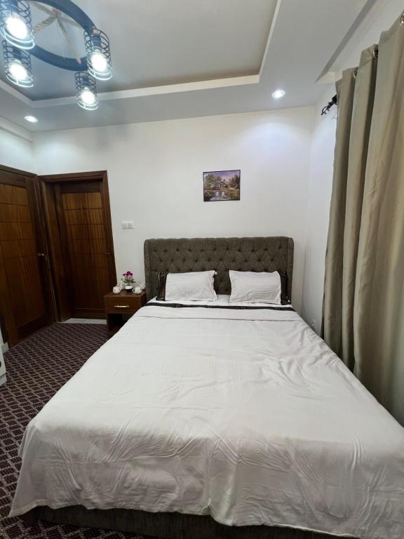 a bedroom with a large white bed in a room at FASA RESIDENCE Dakar CHAMBRE TERANGA in Dakar