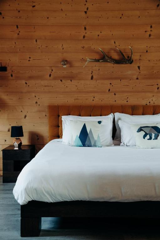 a bedroom with a white bed with a wooden wall at La Villa d'Hélène Chambre d'hôtes BnB - Cluses - Parking Voiture - Moto - Vélo in Cluses