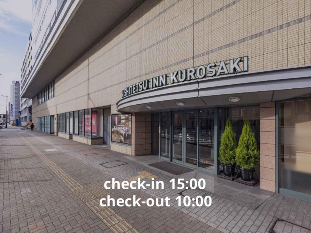 a store with a sign on the side of a building at Nishitetsu Inn Kurosaki in Kitakyushu