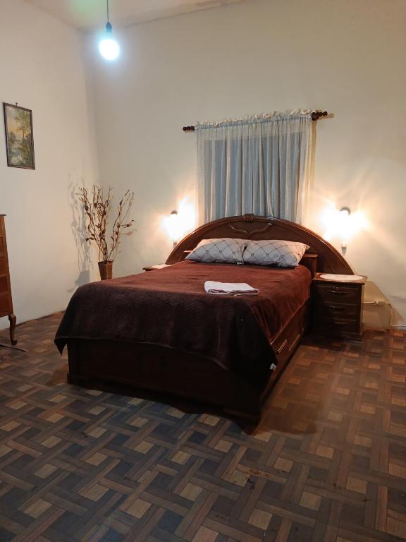 a bedroom with a large bed and a window at Casa Magnolia in Cochabamba