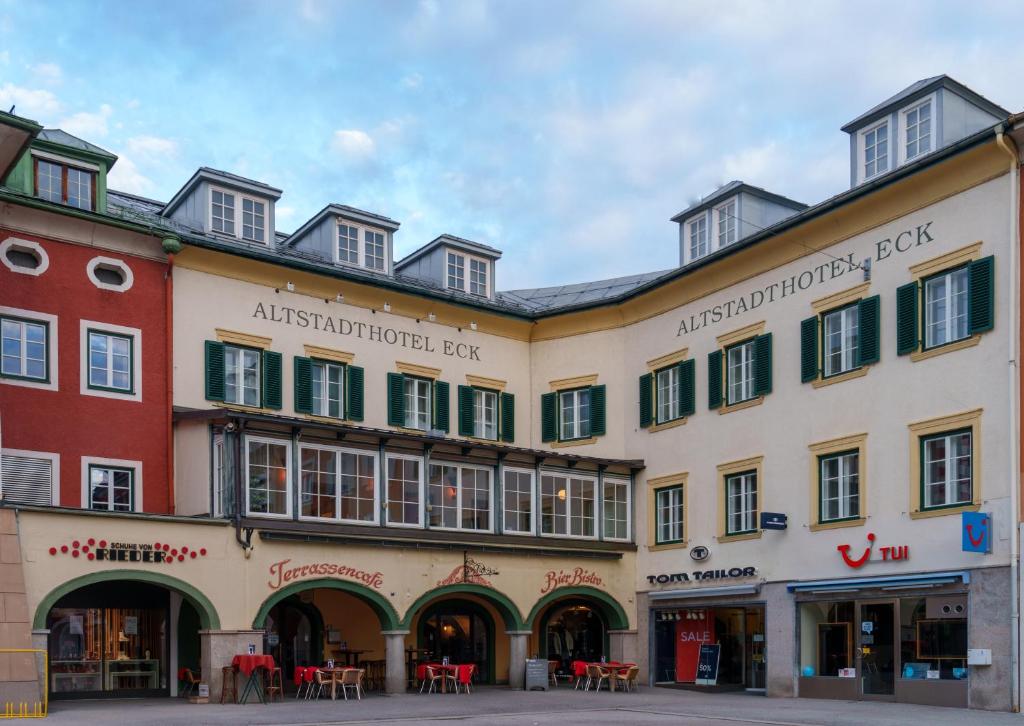 eine Häuserreihe in einer Straße mit Tischen in der Unterkunft Altstadthotel Eck in Lienz