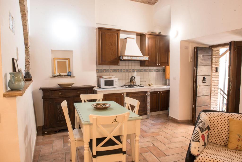 a kitchen with a table and chairs and a microwave at SCAPPO IN UMBRIA, nel vicolo in Amelia