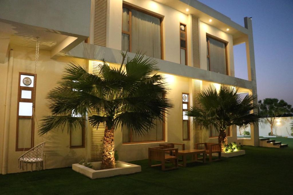 a building with two palm trees in front of it at Istrahtmas1 in Barka
