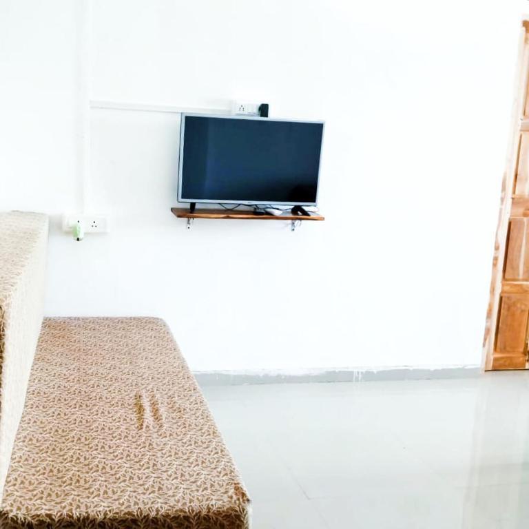 a living room with a tv on a wall at Dapolihideaway in Dapoli