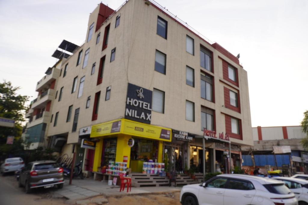 a building on a street with cars parked in front of it at Hotel Nilax in Jaipur