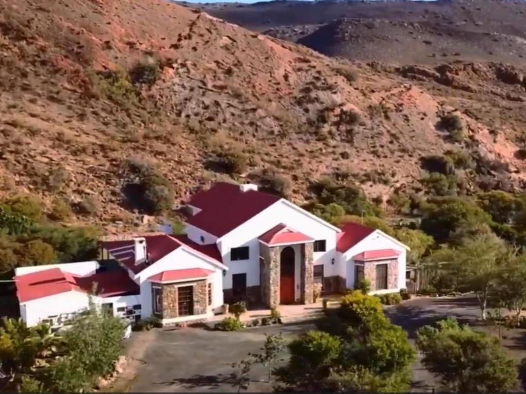 a house with a mountain in the background at Waterval Karoo Guest Farm in Laingsburg