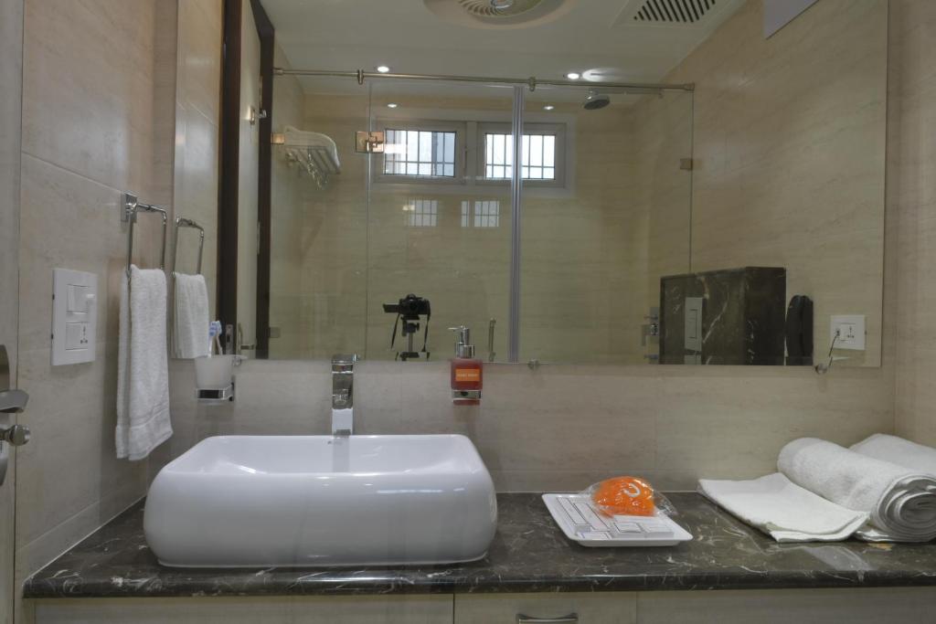 a bathroom with a white sink and a mirror at Hotel Tara Palace Redfort in New Delhi