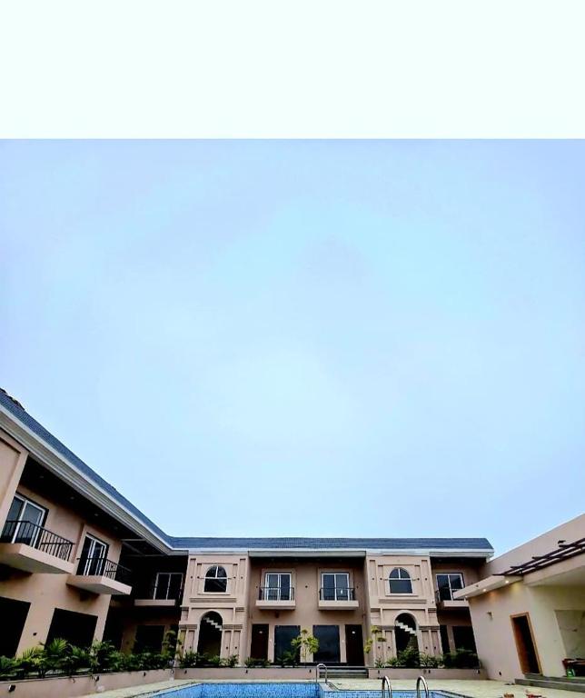a large apartment building with a swimming pool at R N Hotel & Lawn in Katra