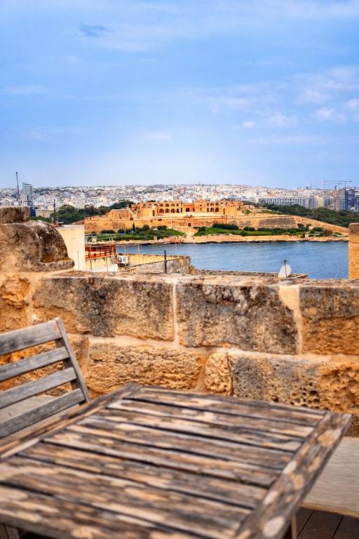 a table and a chair sitting on top of a wall at Valletta Maisonette Malta in Valletta