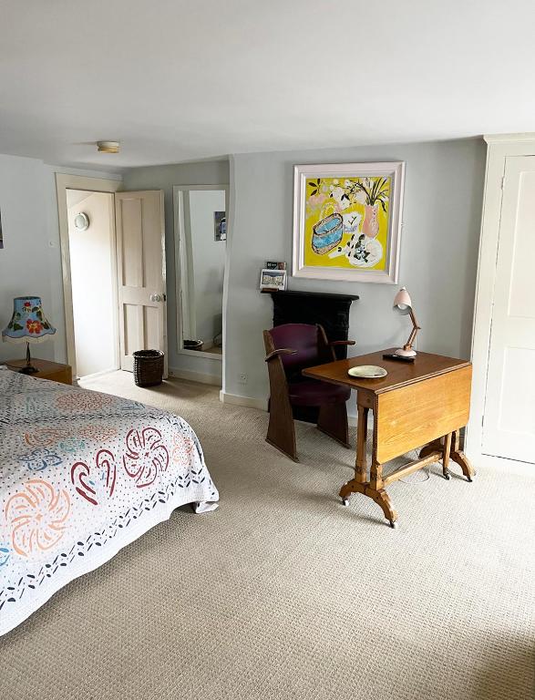 a bedroom with a bed and a desk and a table at The Artist's House in Norwich