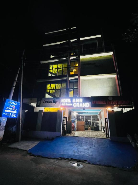 a building at night with a sign in front of it at Hotel ANR Grand in Visakhapatnam