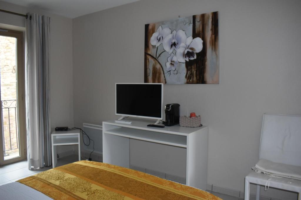 a bedroom with a desk with a television on it at Carpe Diem 3 in Goutrens