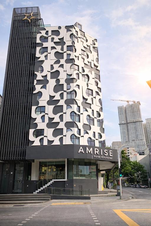 a tall white building with a sign in front of it at Amrise Hotel Kitchener, Check In 9PM, Check Out 8AM in Singapore
