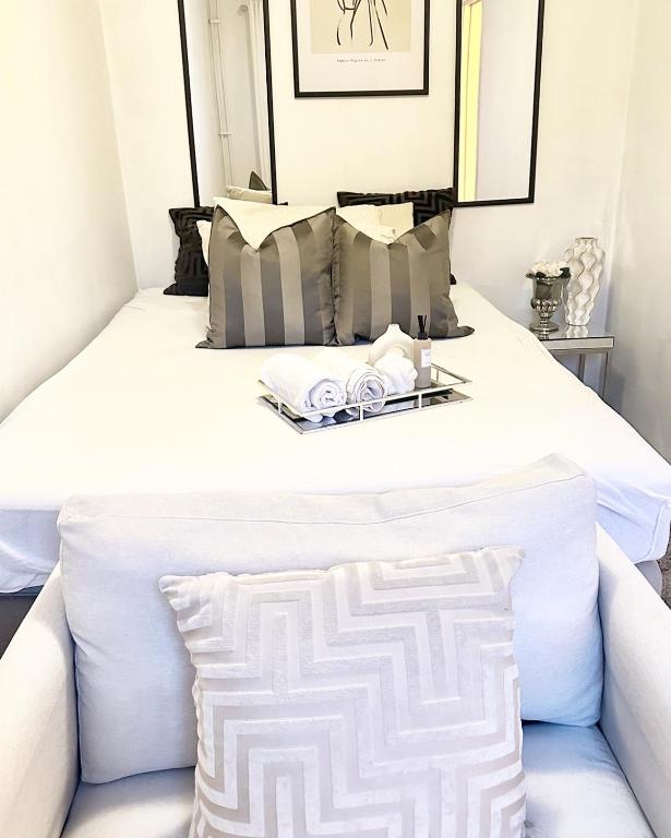a white bed with a tray of towels on it at Private room central in Oslo