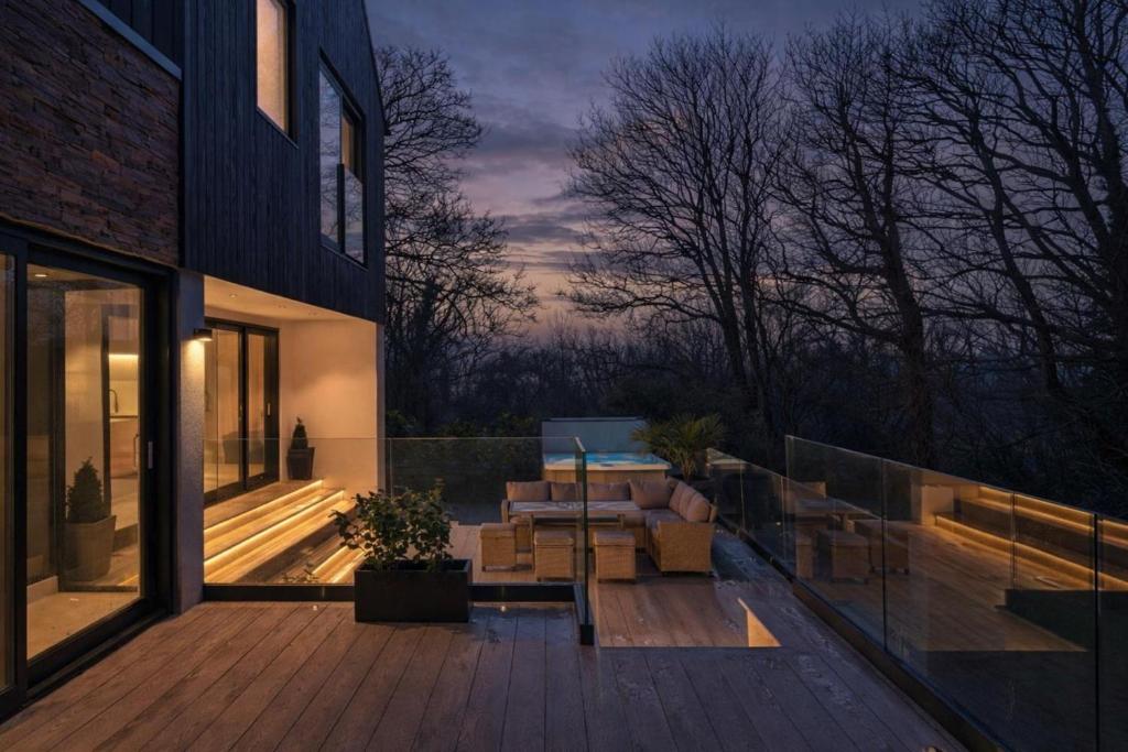a patio with a couch and a table on a deck at Finest Retreats - Orchard Rise in Bude