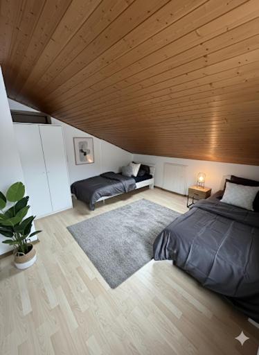 a bedroom with two beds and a wooden ceiling at Monteurzimmer Schäfer - Rhein Main in Hösbach
