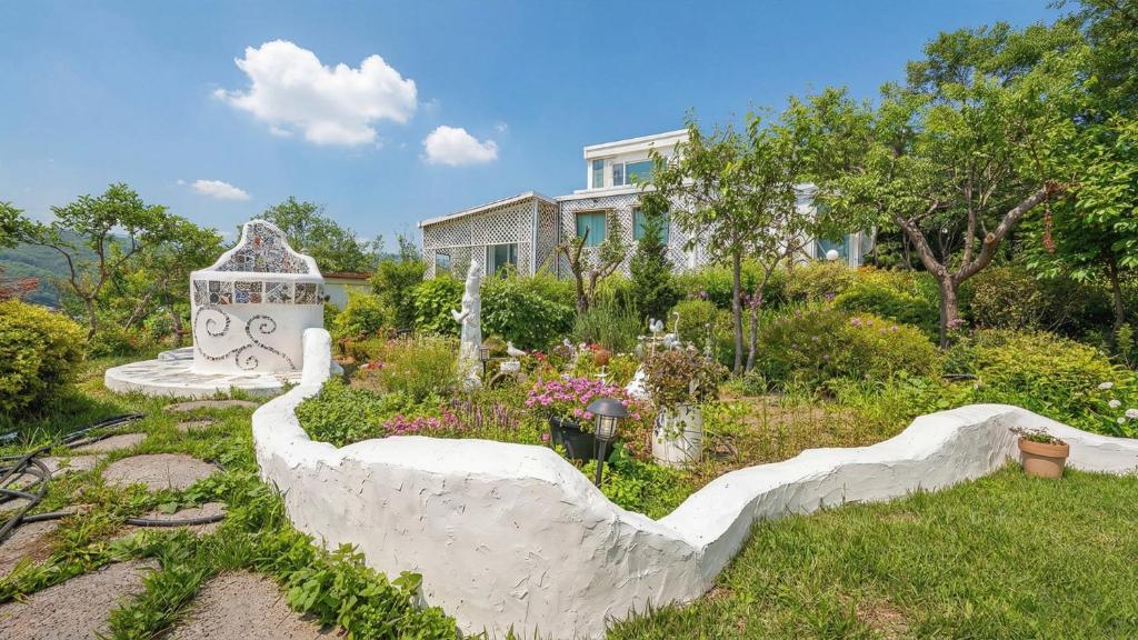 a garden with a statue in front of a house at Ganghwa Picnic Pension in Incheon