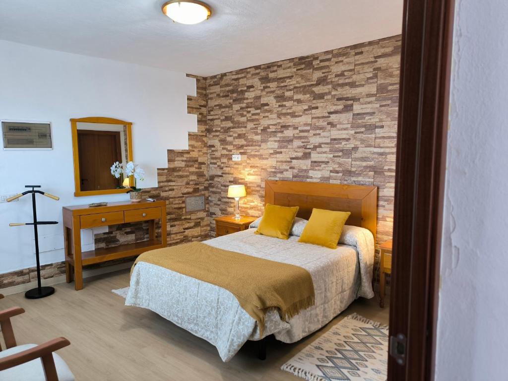 a bedroom with a bed and a brick wall at Casa Chemar in La Orotava