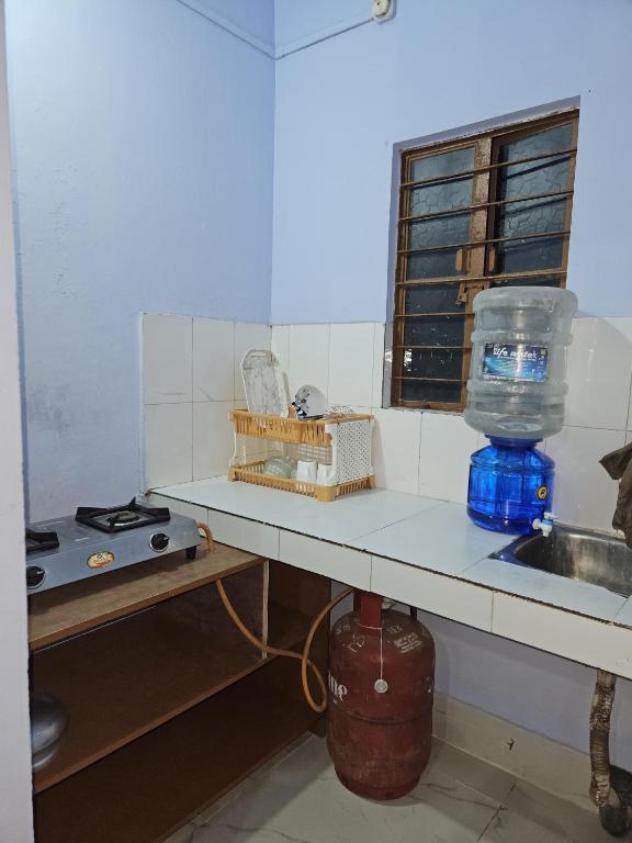 a kitchen with a counter and a sink and a window at HACHIKOs HAVEN in Guwahati