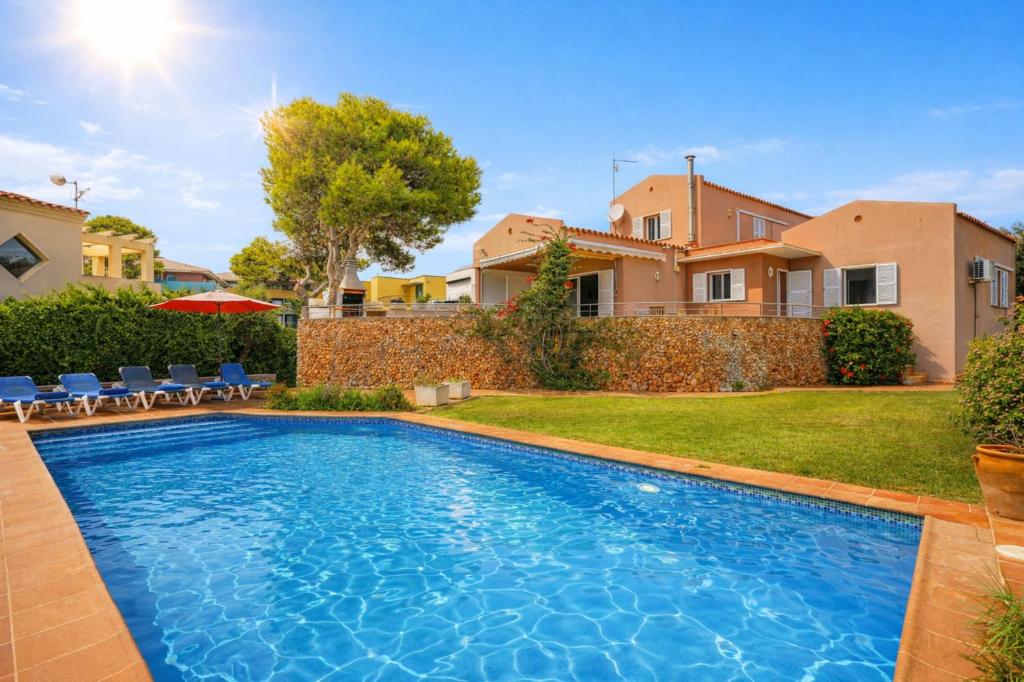 a swimming pool in the backyard of a house at Villa Betonia in Punta Prima