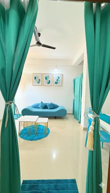 a room with blue curtains and a blue couch at Serenyaa in Dibrugarh
