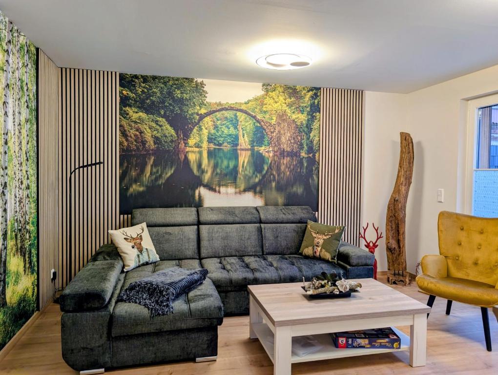 a living room with a couch and a painting of a bridge at Ferienwohnung Forest Life in Hasselfelde