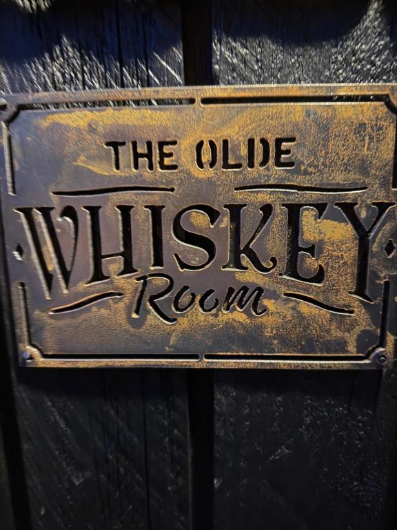 a metal sign that reads the village village room at The Olde Whiskey Room in Queenstown